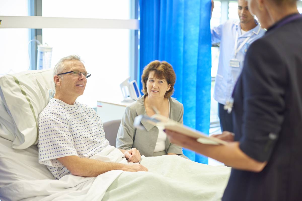 A medical professional helps prepare a patient ahead of surgery